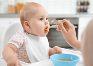 Showing baby being fed puree food rather than baby led weaning.